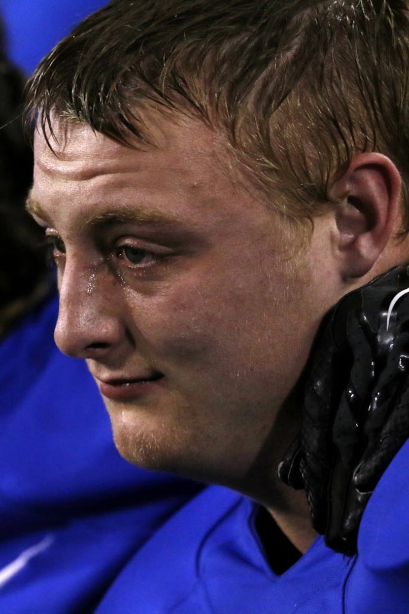 Krum's Coleton Spradley sits on the bench with a tear near his eye in the 3rd quarter as...