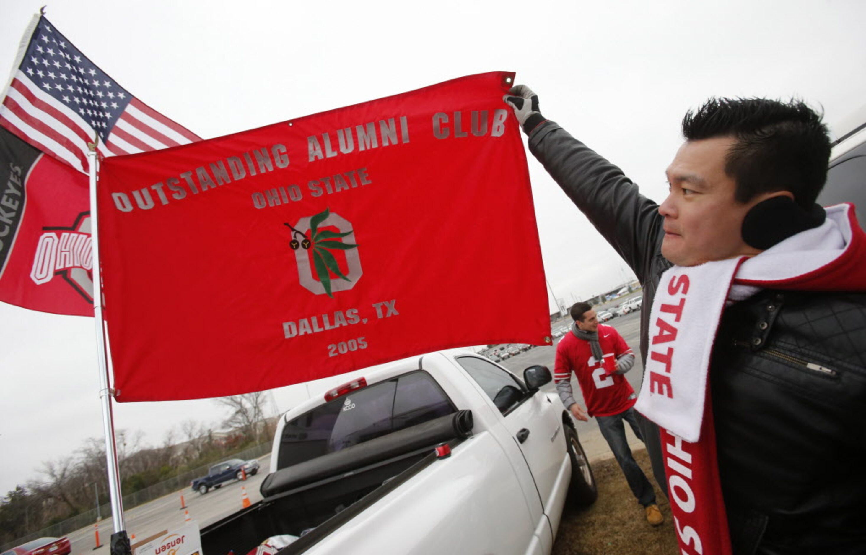 Local alumni president Mike Liang proudly displays the flag as he tailgates with friends...