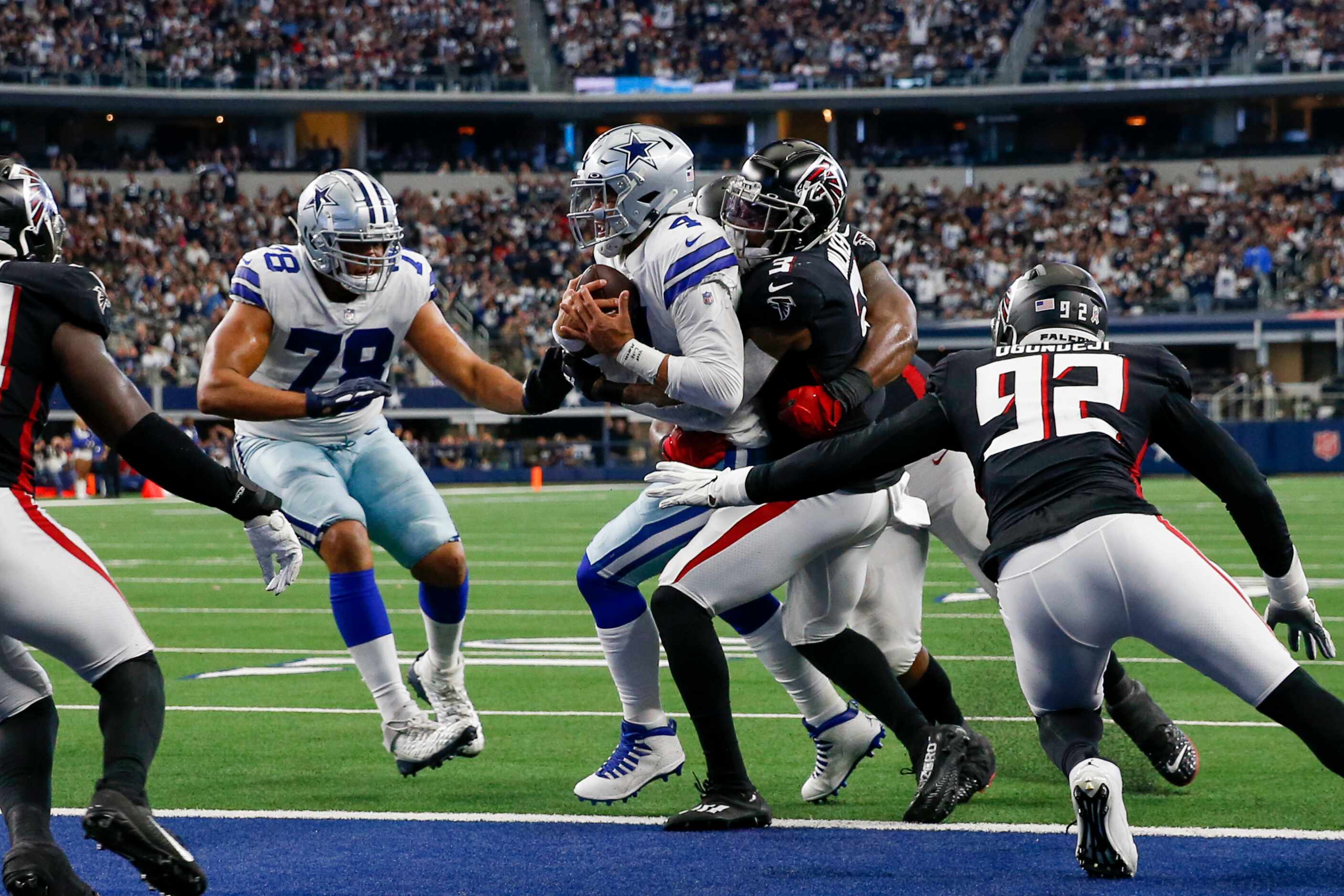 Dallas Cowboys quarterback Dak Prescott (4) carries Atlanta Falcons linebacker Mykal Walker...