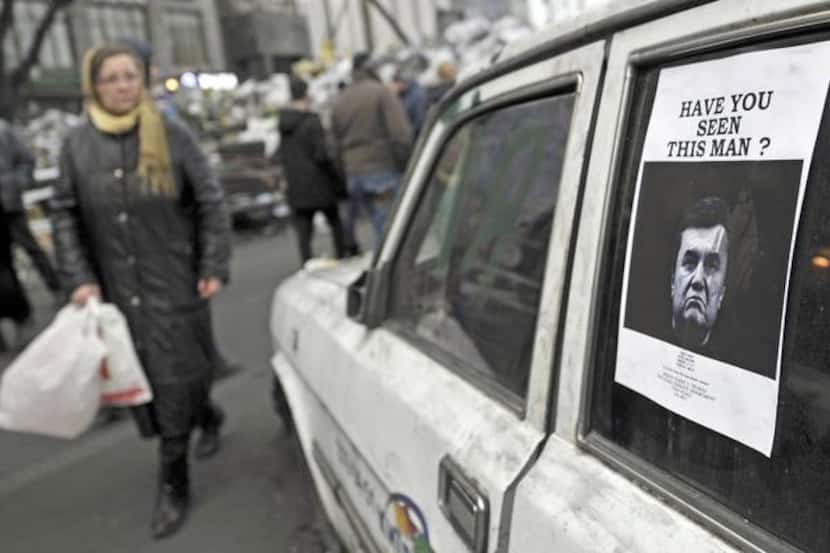 
A wanted poster showing a portrait of ousted President Viktor Yanukovych is displayed on a...