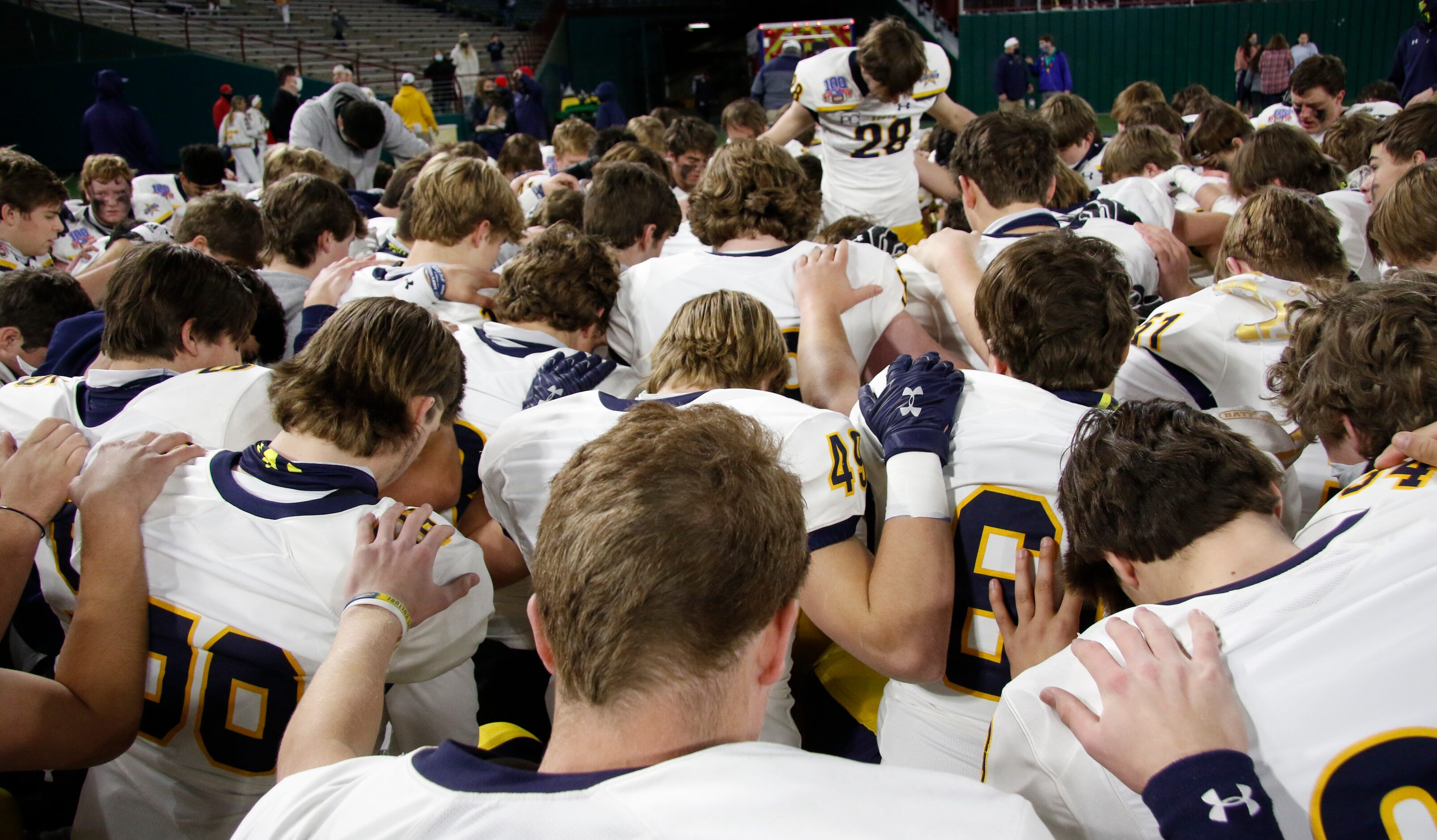 Highland Park Scots players take a knee as they are led by defensive back Ford Frazar (28)...