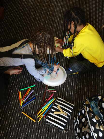 Yannoj Young, 8 (left) and her sister Courtney Young, 7 draw on disposable plates inside...