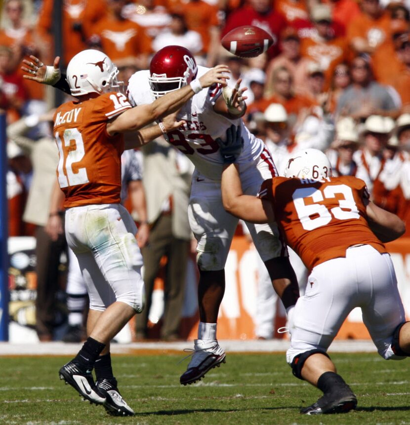 Texas quarterback Colt McCoy (12 - left) gets a pass away despite onrushing Oklahoma...