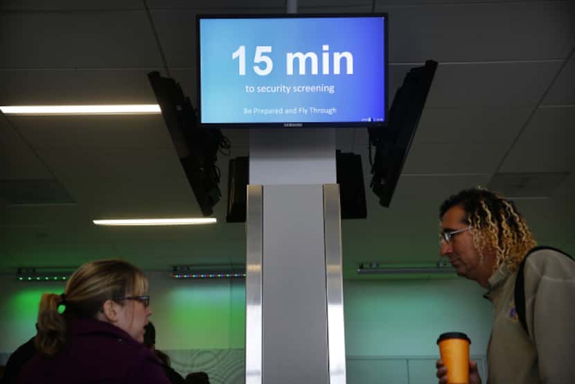 Video boards along the "Next Level"   security checkpoint keep travelers apprised of how...