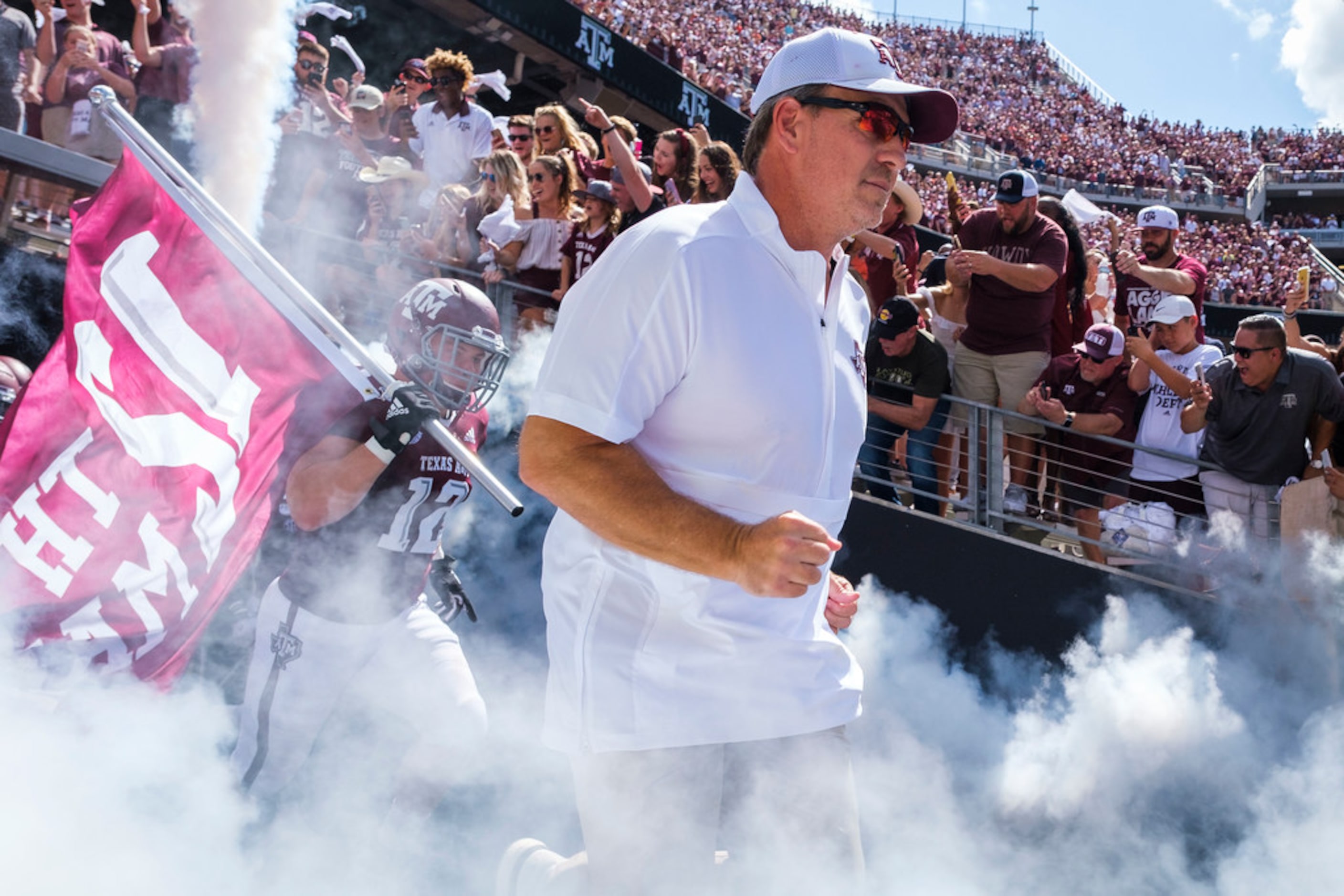 Texas A&M head coach Jimbo Fisher leads his team as they take the field to face Auburn in an...