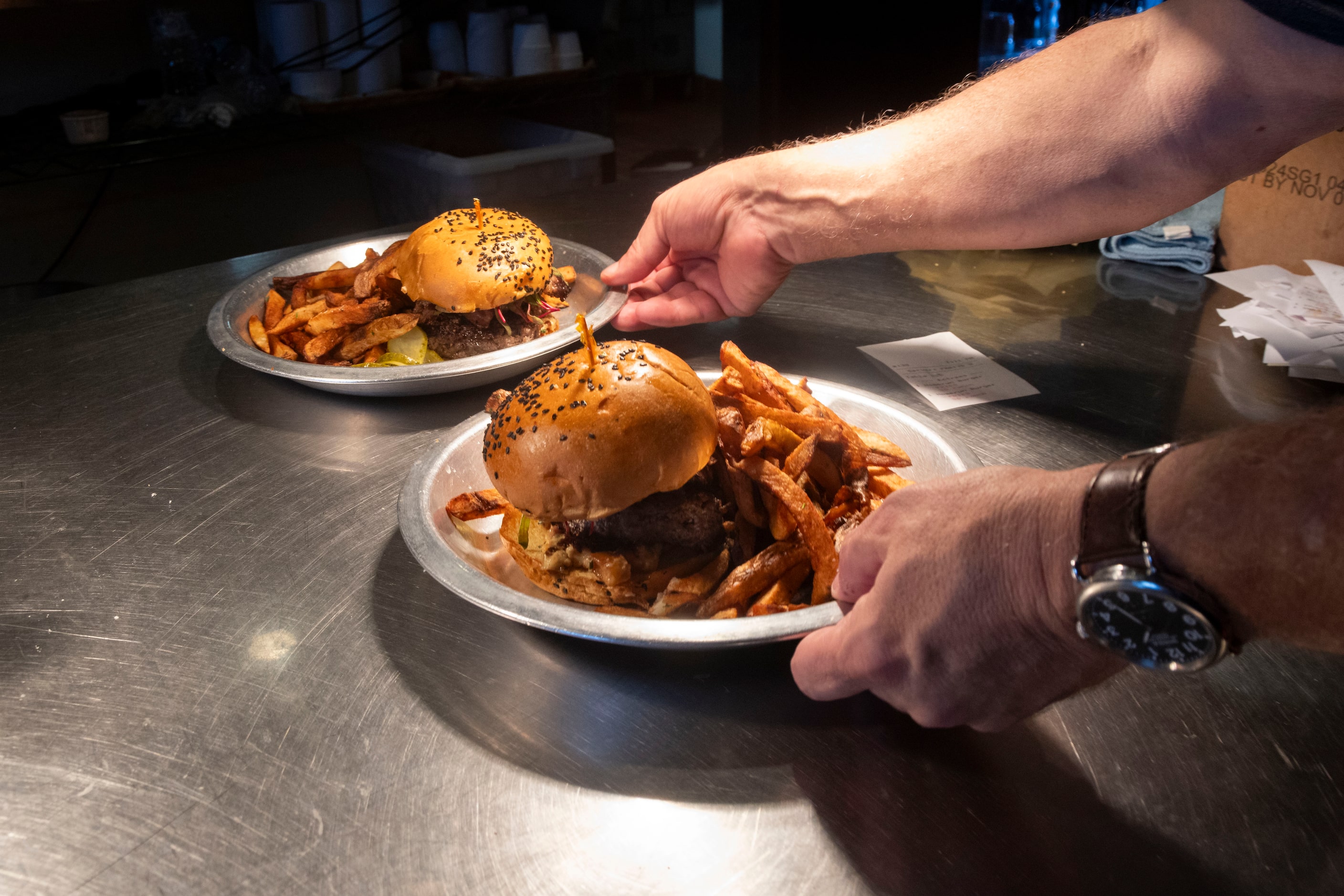 The Dallas Morning News’ Rangers reporter Evan Grant carries the Evan Grant Burgers as he...