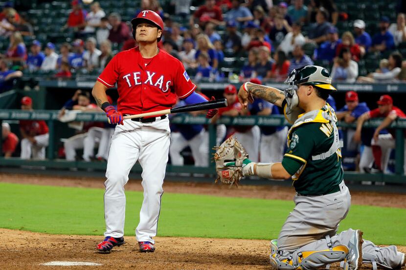Texas Rangers' Shin-Soo Choo, left, of South Korea, balks away from the plate after taking a...