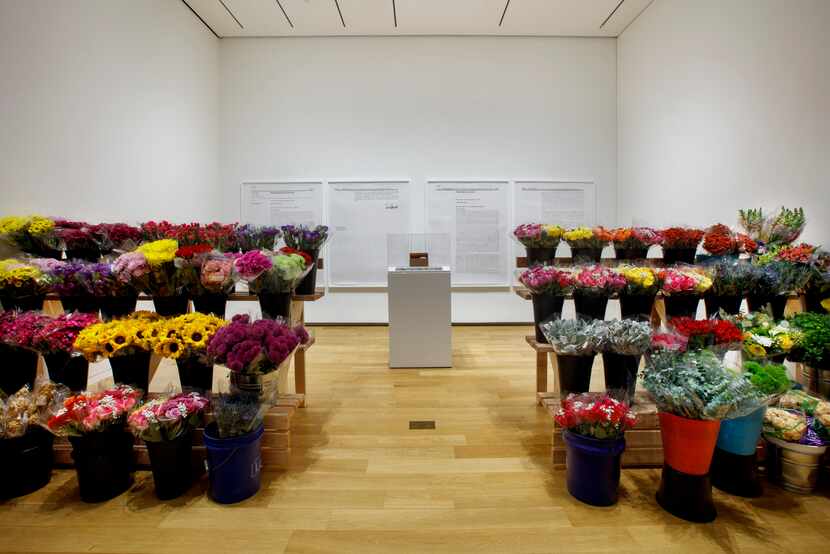 Jill Magid's "Bodega Flowers" consists of tiers of fresh flowers wrapped in cellophane and...