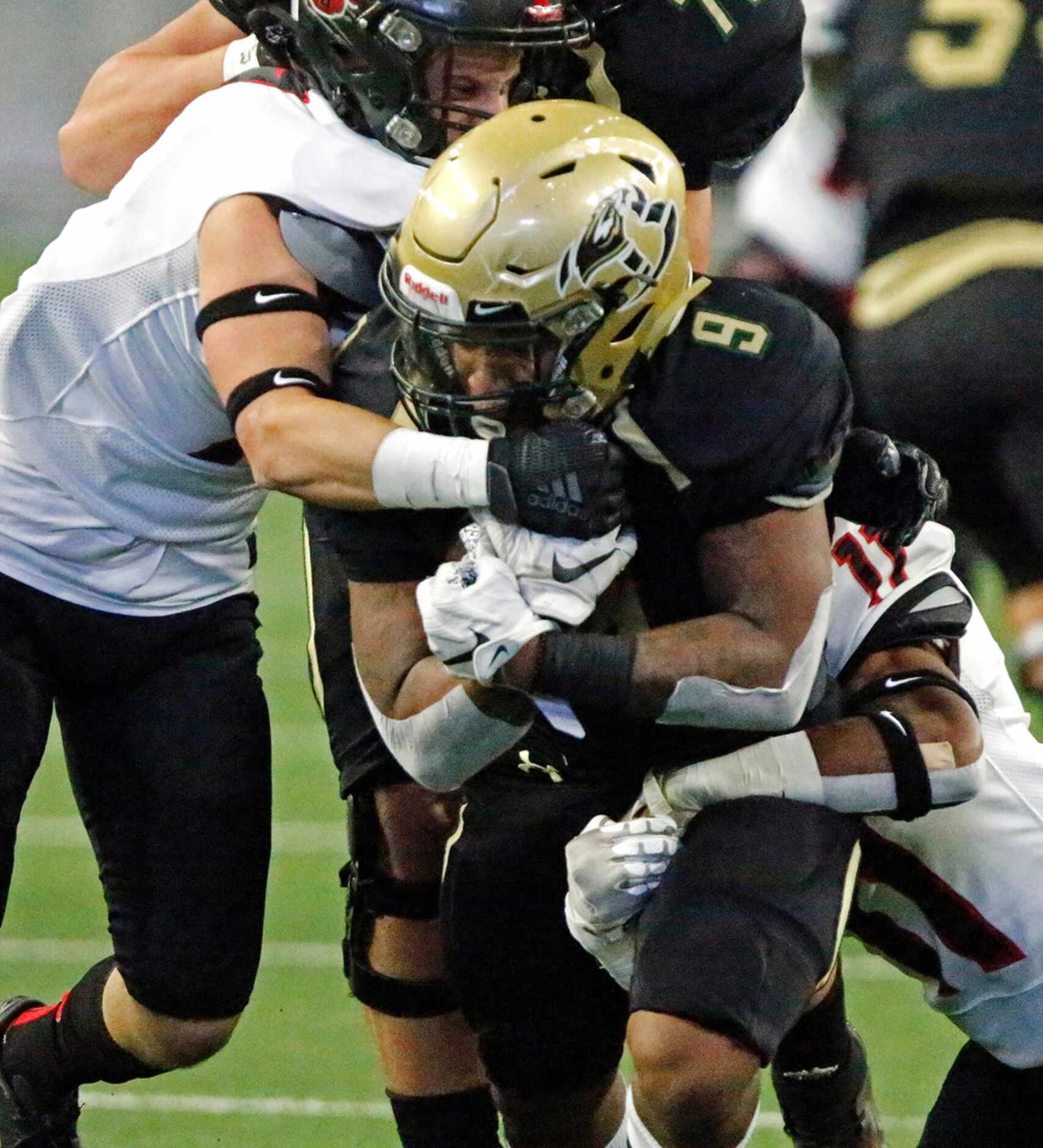 Birdville High School running back Laderrious Mixon (9) is brought down by Colleyville...