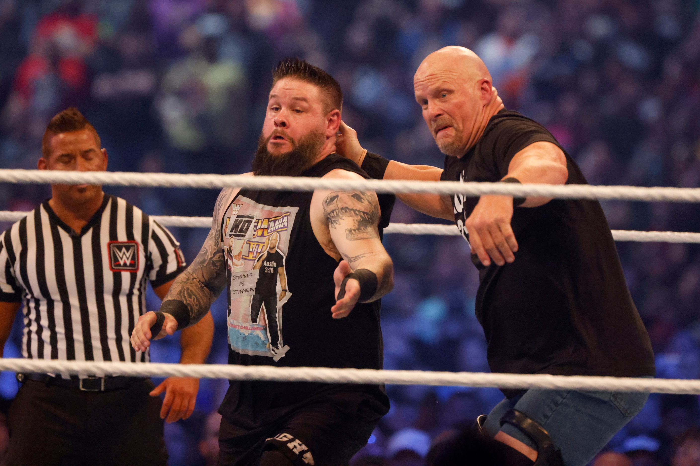 “Cold Stone” Steve Austin tries to throw Kevin Owens, left, out of the ring during...