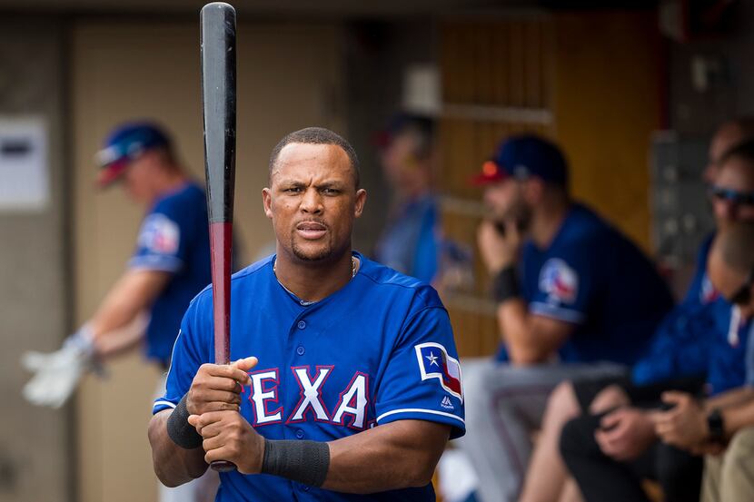 Texas Rangers designated hitter Adrian Beltre picks up a bat in the dugout during the second...