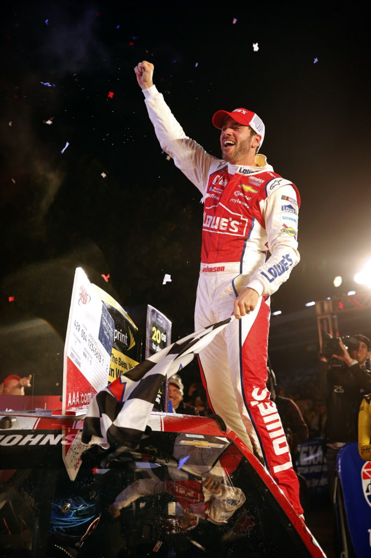 Sprint Cup Series driver Jimmie Johnson (48) stands on his car window as he celebrates his...