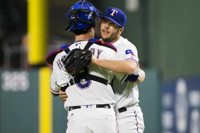 Texas Rangers relief pitcher Shawn Tolleson hugs catcher Bryan Holaday after recording the...
