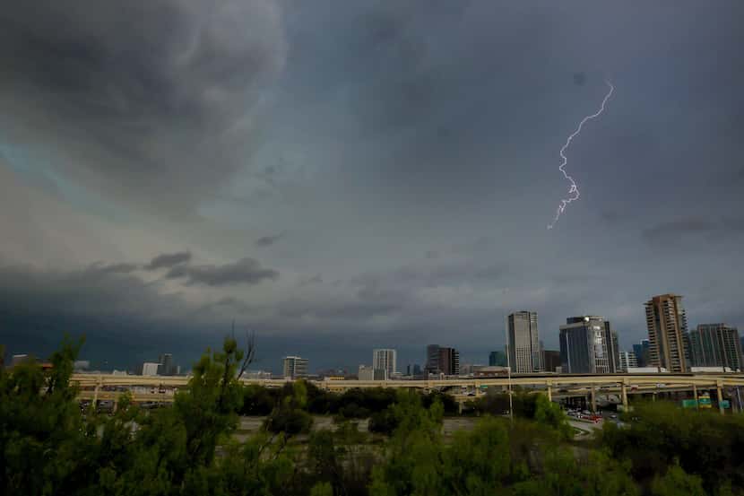 Lighting lights up the sky as storm clouds gather over downtown Dallas on Thursday, March...