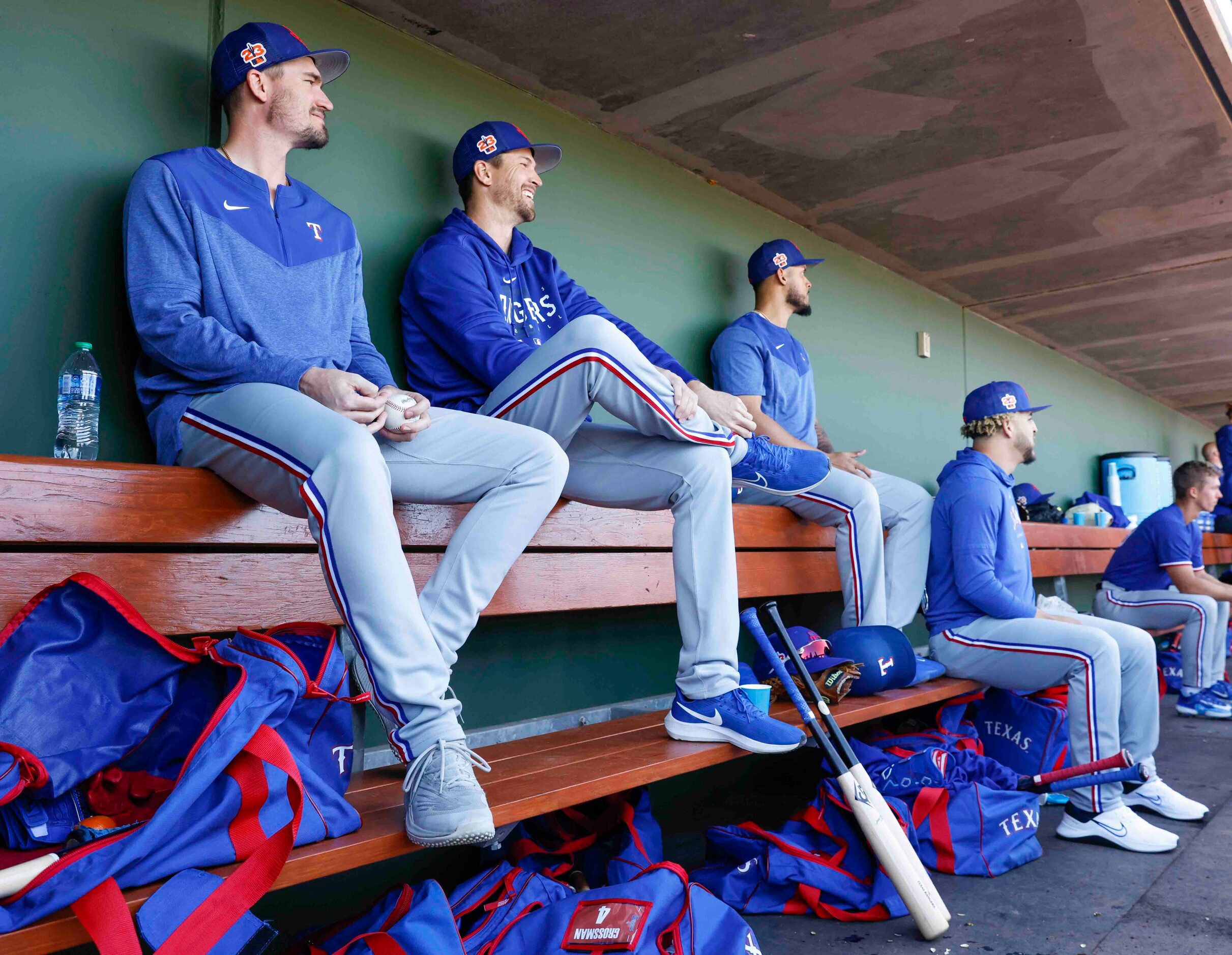 Texas Rangers pitchers Andrew Heaney, left, and Jacob deGrom sit in the dugout during a...