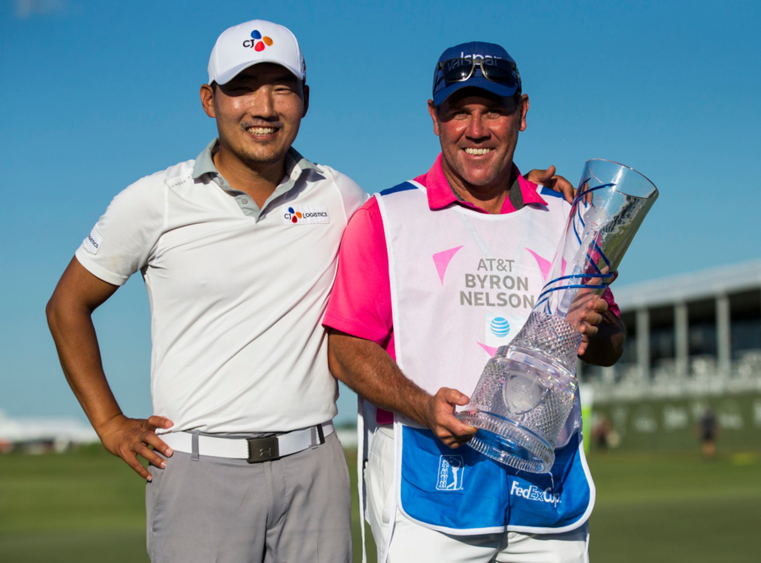 Sung Kang (left) and his caddie, Jason Shortall, pose with the AT&T Byron Nelson trophy...