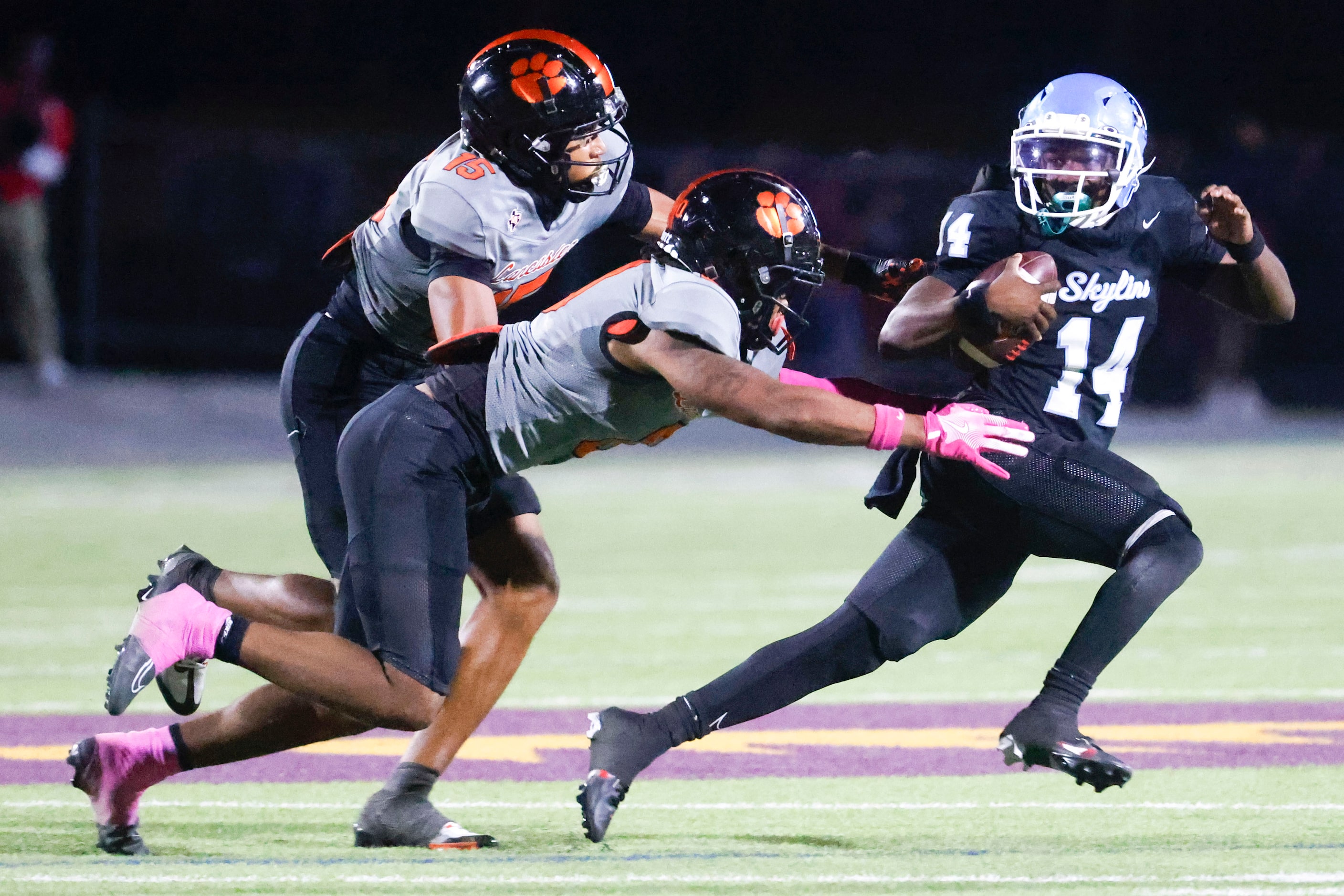 Skyline High’s Donta Ware (14) runs past Lancaster high’s James Foster (15) and Ke’Breion...