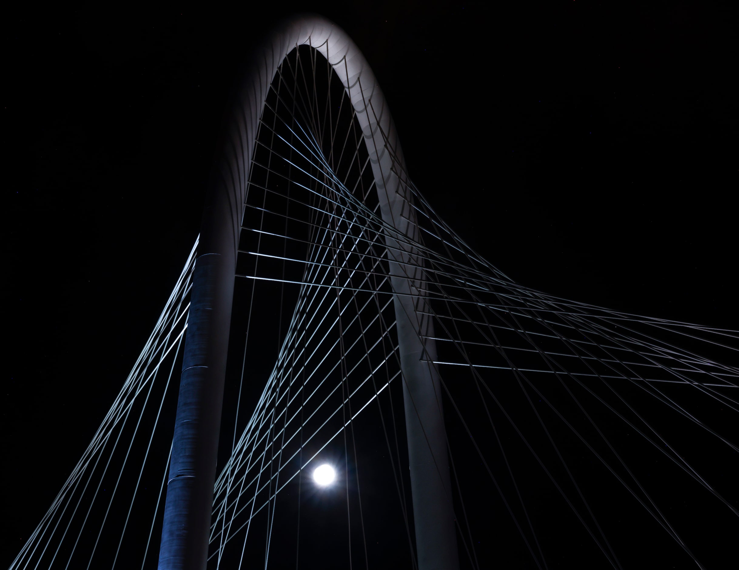 A partial lunar eclipse and super harvest moon shines behind the Margaret Hunt Hill Bridge,...