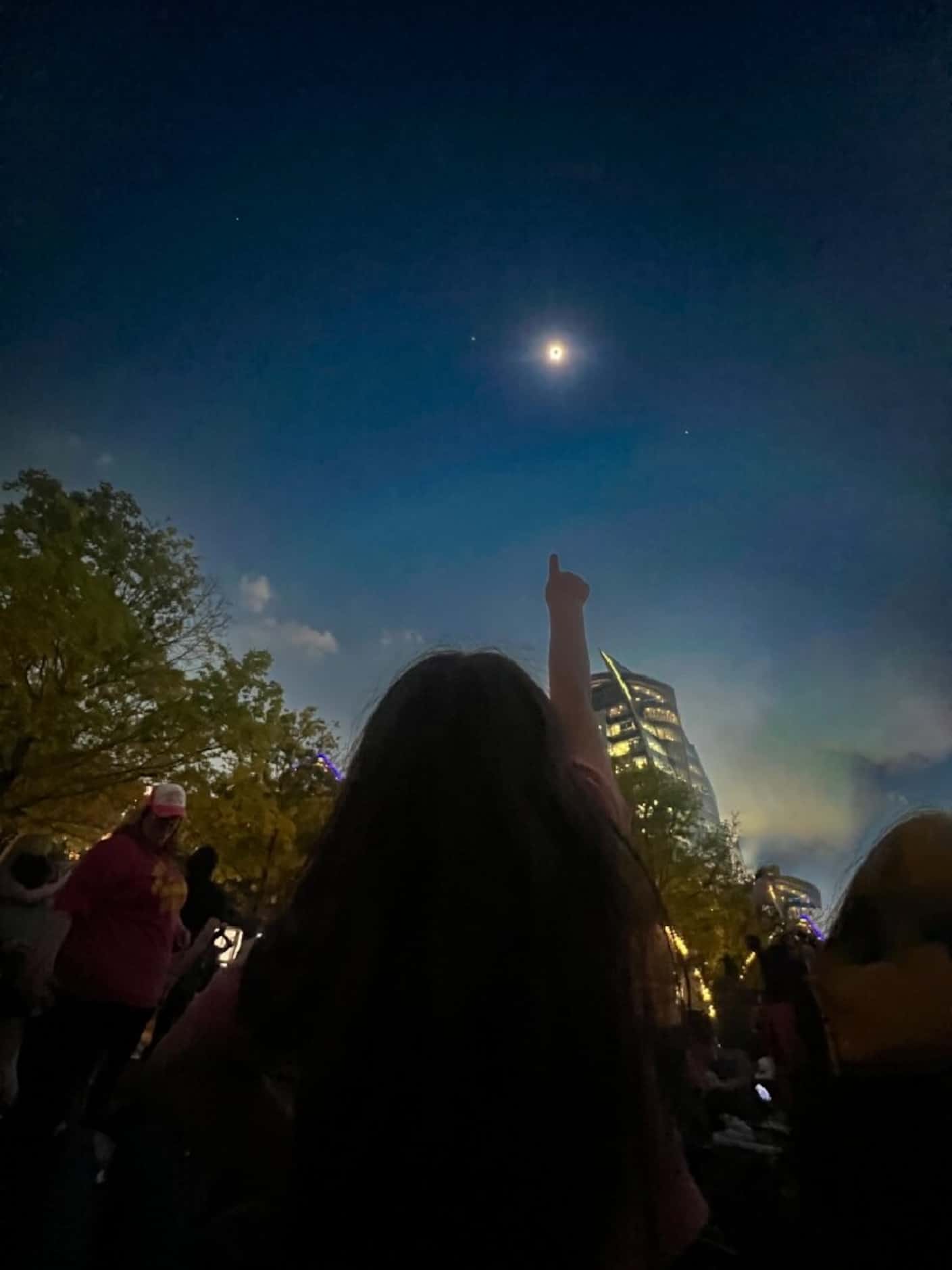 A person points toward the April 8 total solar eclipse at Kylde Warren Park in Dallas....