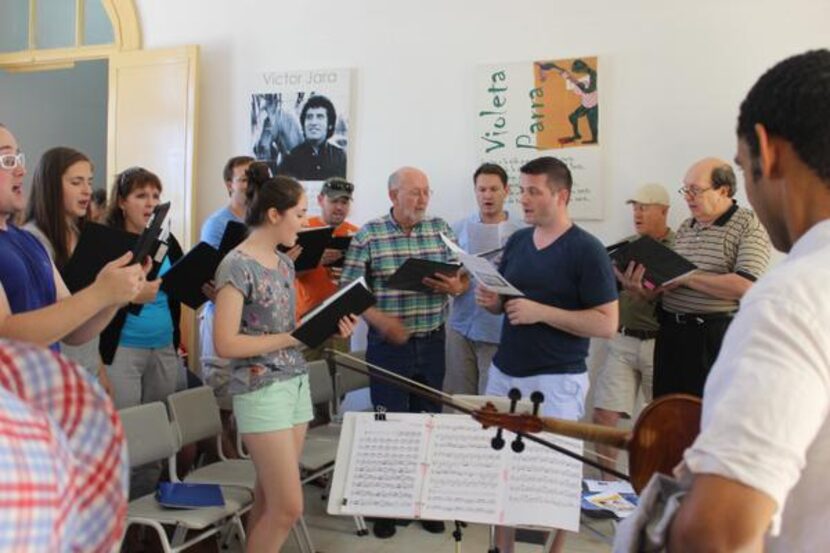 
Credo Choir conductor Jonathan Palant (front right, in black T-shirt) leads the group at...