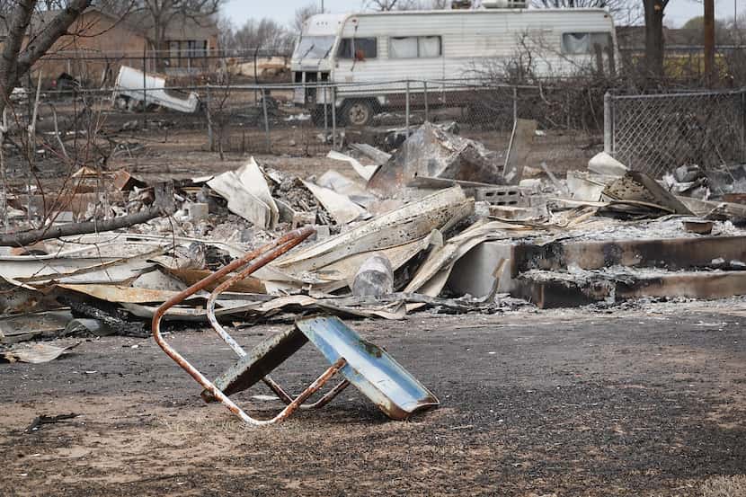 A lawn chair sat toppled in front of a leveled home in the aftermath of the Smokehouse Creek...