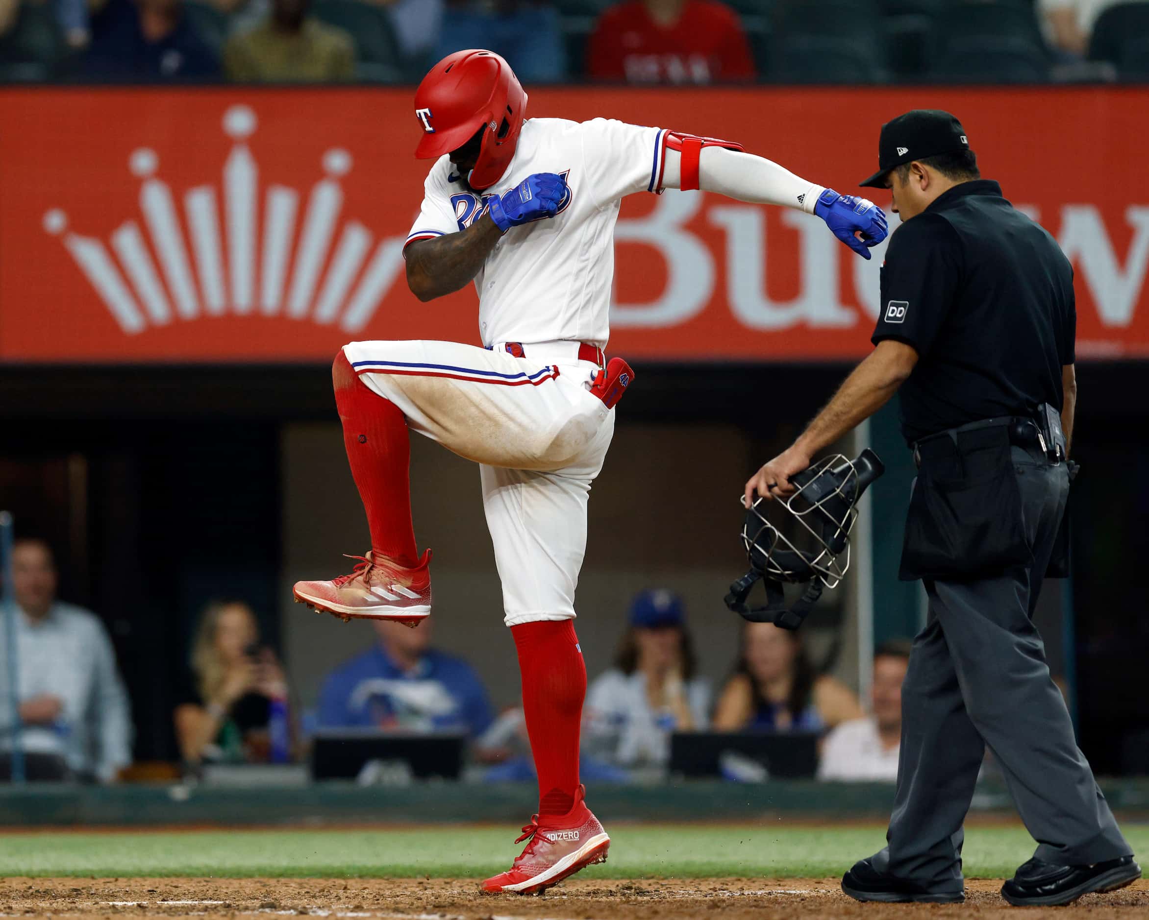 Texas Rangers right fielder Adolis Garcia (53) stomps on home plate after hitting a home run...