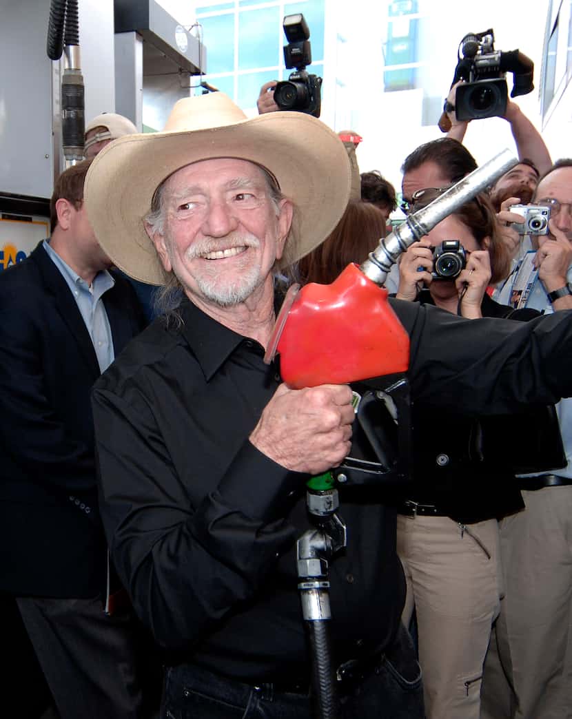  Singer Willie Nelson holds up the pump before filling his bus with Bio Willie diesel fuel,...