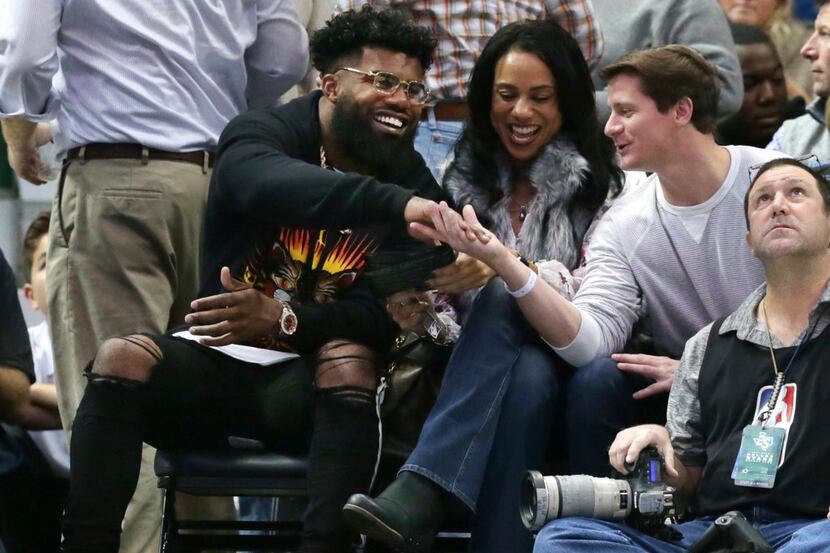 Dallas Cowboys running back Ezekiel Elliott, left, shakes hands with a fan during the first...
