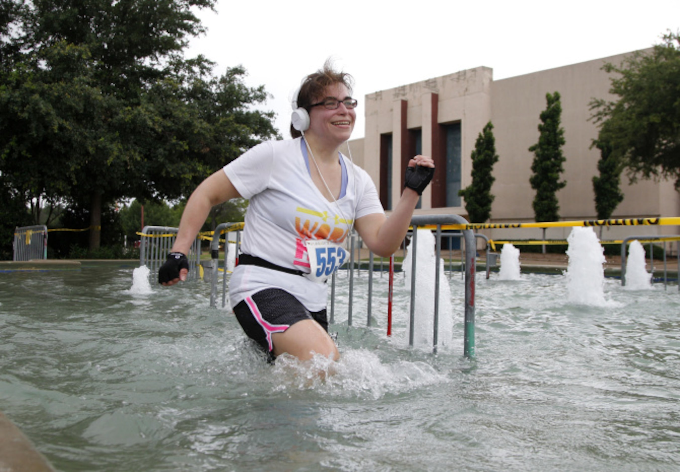 Karen Peck races thru a fountain during the Second Annual  Fair Park 5K Urban Dash Saturday...