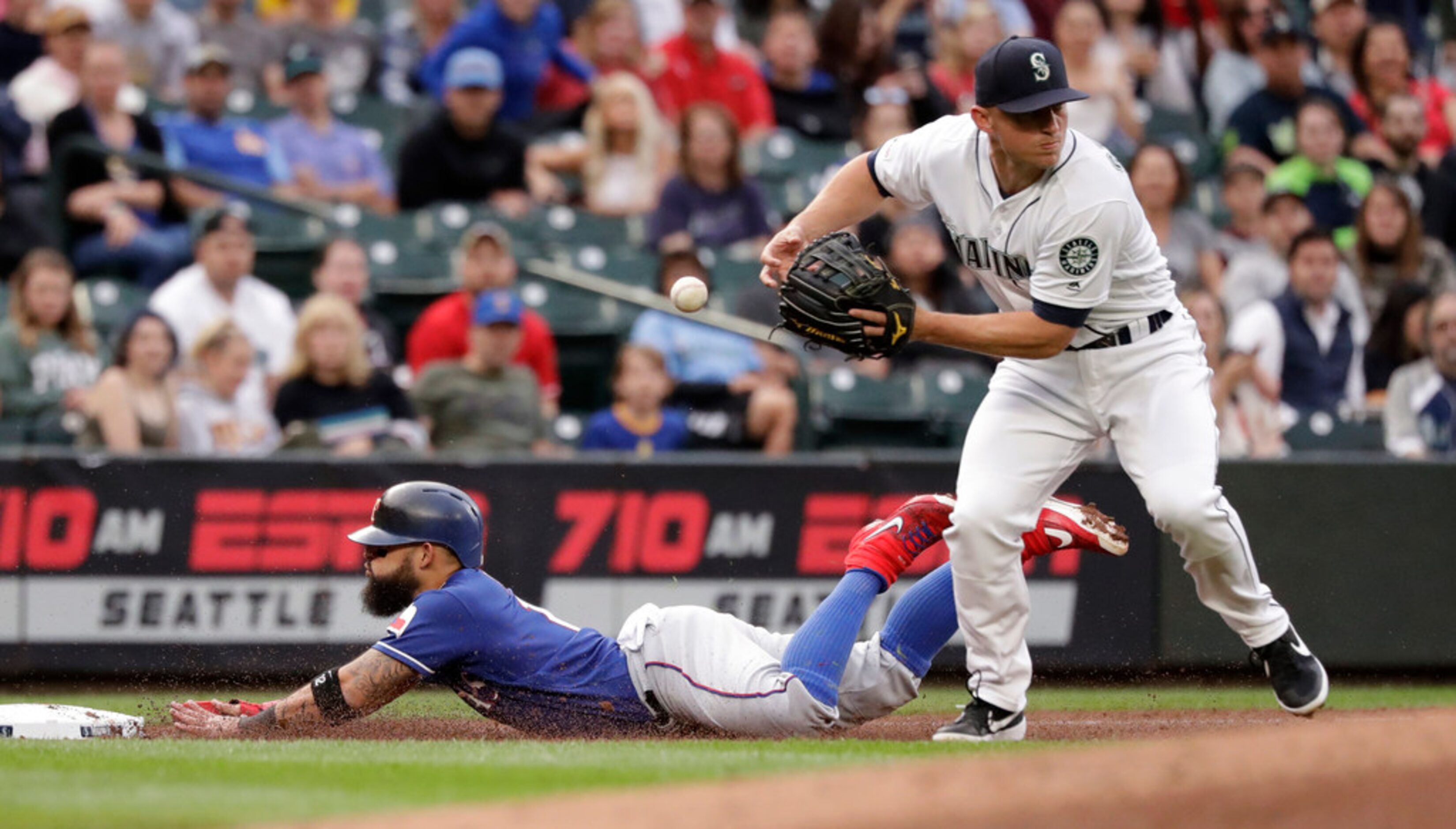 Texas Rangers' Rougned Odor, left dives safely into third base as Seattle Mariners third...