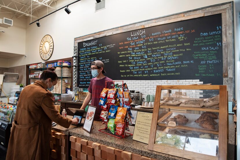 Employee John Paul Gordon, right, closes a sale with customer Kat Gleason, left, at Brown...