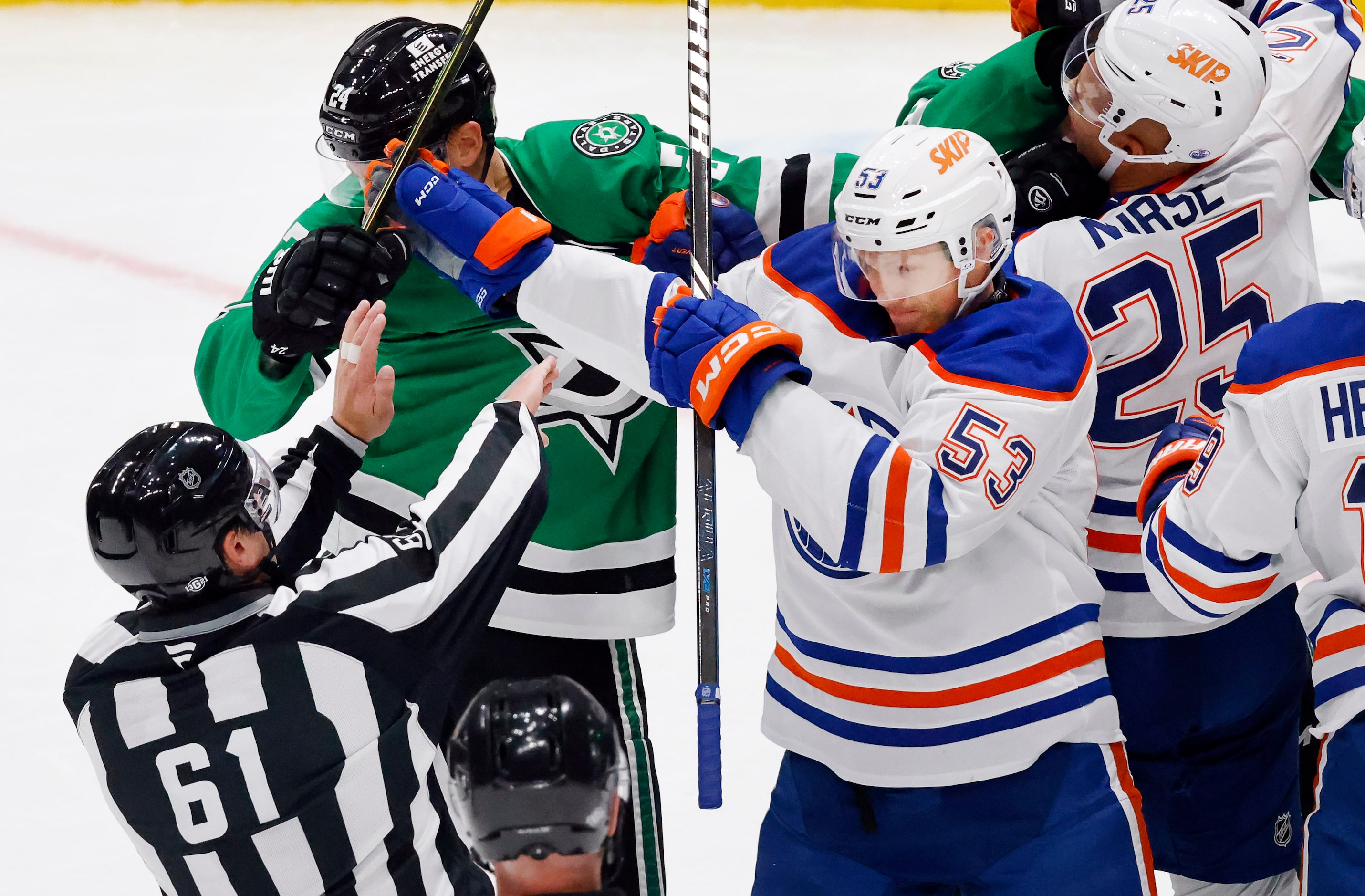 Linesman James Tobias (61) tries to separate Dallas Stars center Roope Hintz (24) and...