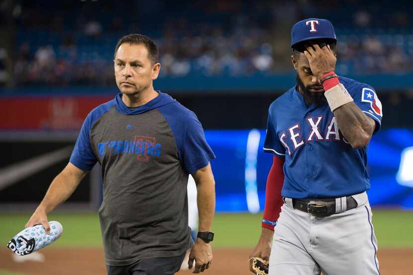 Texas Rangers center fielder Delino DeShields, right, walks back to the dugout with the...