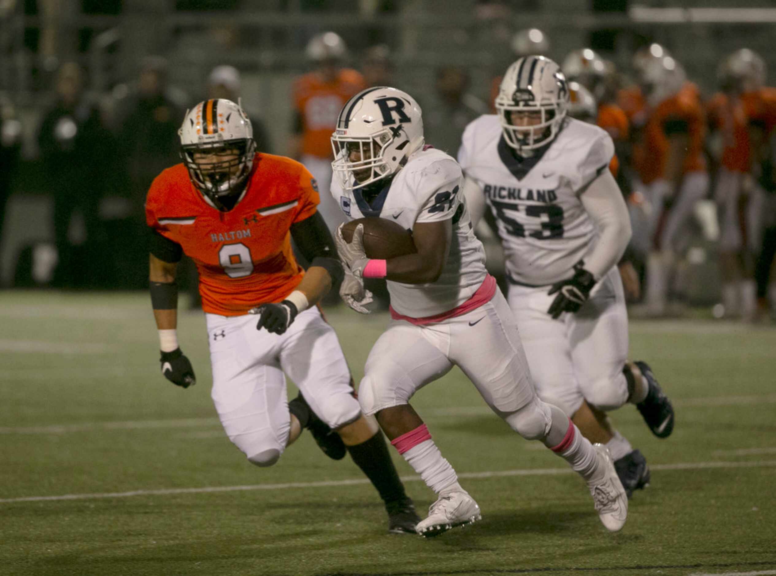 Richland's Brandon Johnson (21) tries to run past Halton's Brandon Thammavong during the...