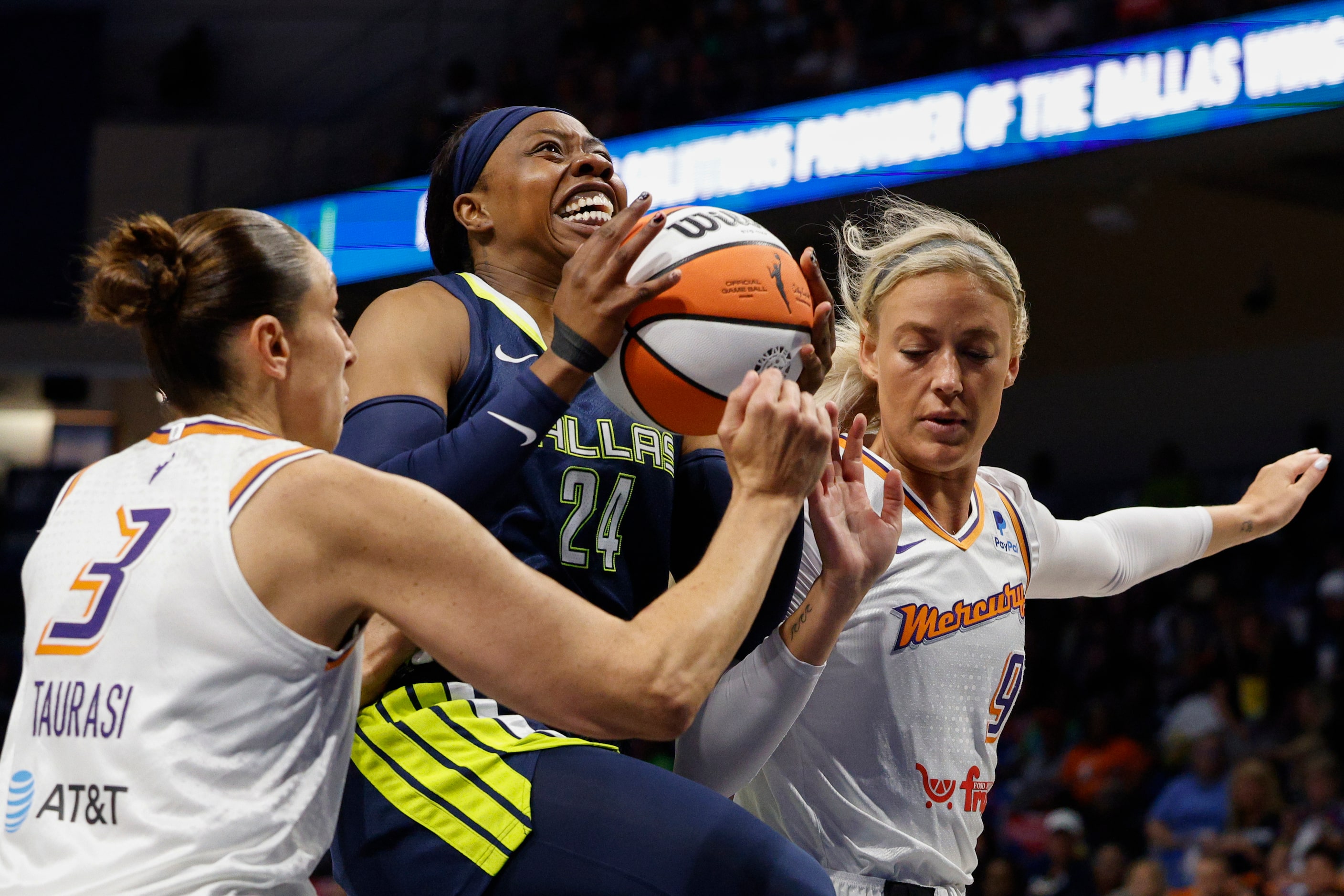 Dallas Wings guard Arike Ogunbowale (24) drives to the basket between Phoenix Mercury guard...