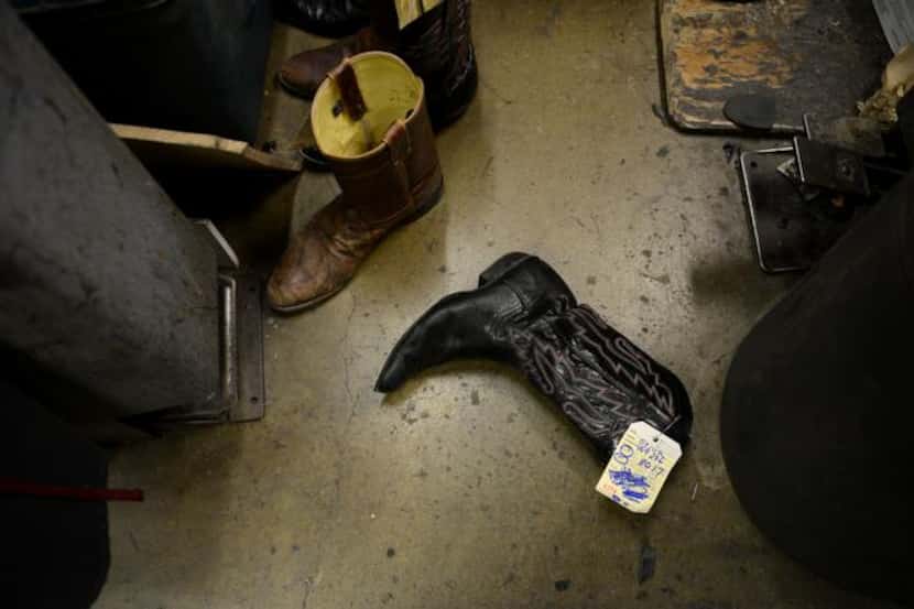 
Cowboy boots lay on the floor waiting to be repaired in the back room of Messina Shoe...