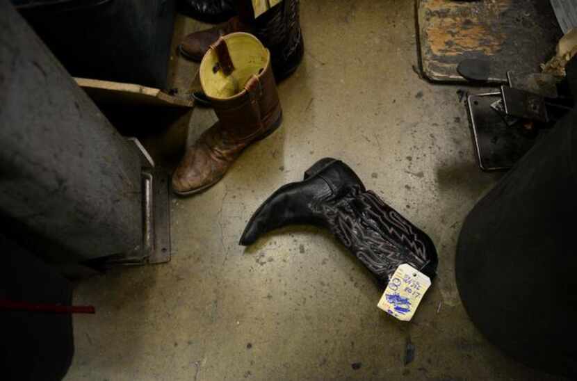 
Cowboy boots lay on the floor waiting to be repaired in the back room of Messina Shoe...