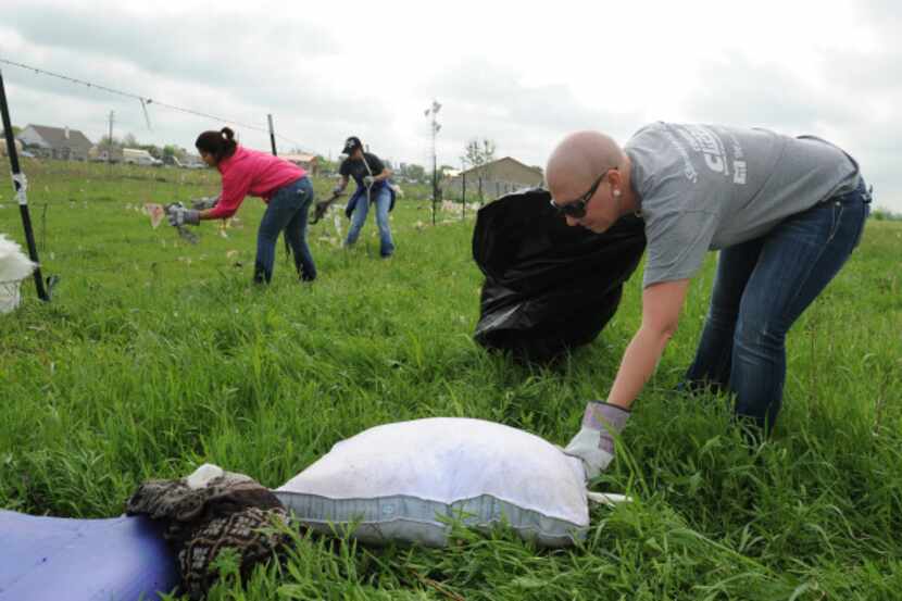 Amy Hardman picked up a pillow as she and other volunteers helped clean up Forney's Diamond...
