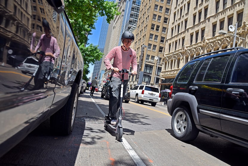 Matthew Bashover, 60, test rides a Bird electric scooter along Main Street as the company...