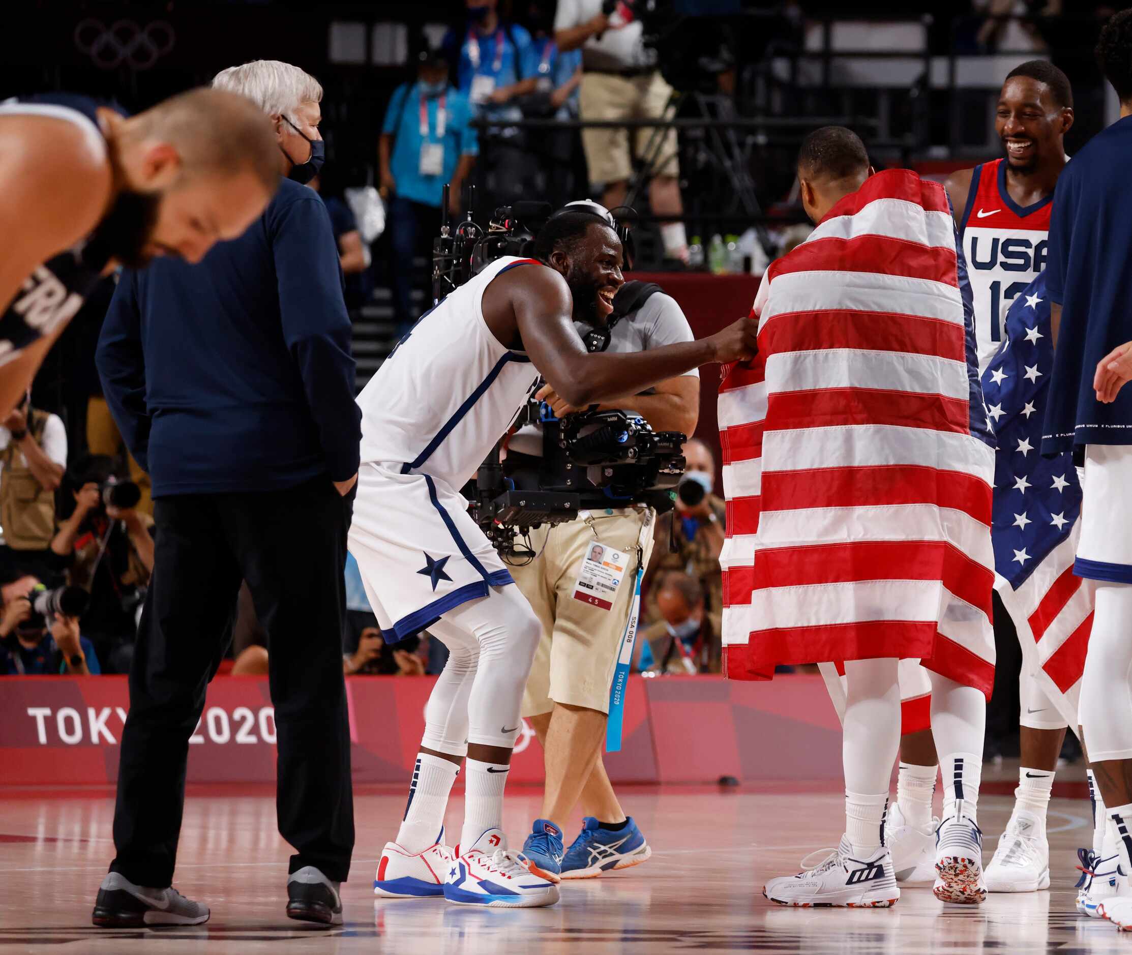 USA’s Draymond Green (14) helps drape Damian Lillard (6) with a flag after they defeated...