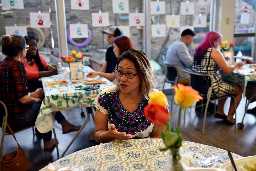 Gloria Lopez, chief executive officer of Trinity River Mission, sits with staff and...