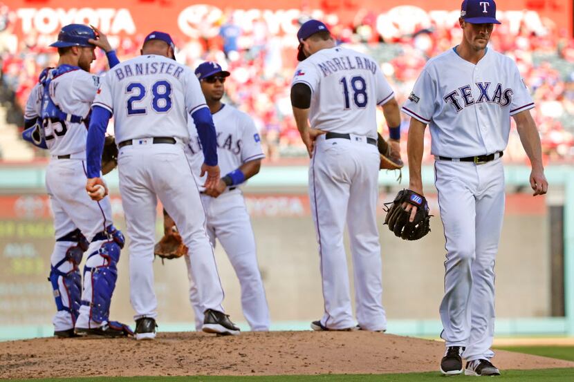 Texas Rangers starting pitcher Cole Hamels (35), right, walks off the mound after  being...