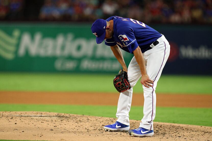 ARLINGTON, TEXAS - SEPTEMBER 14: Mike Minor #23 of the Texas Rangers reacts after giving up...