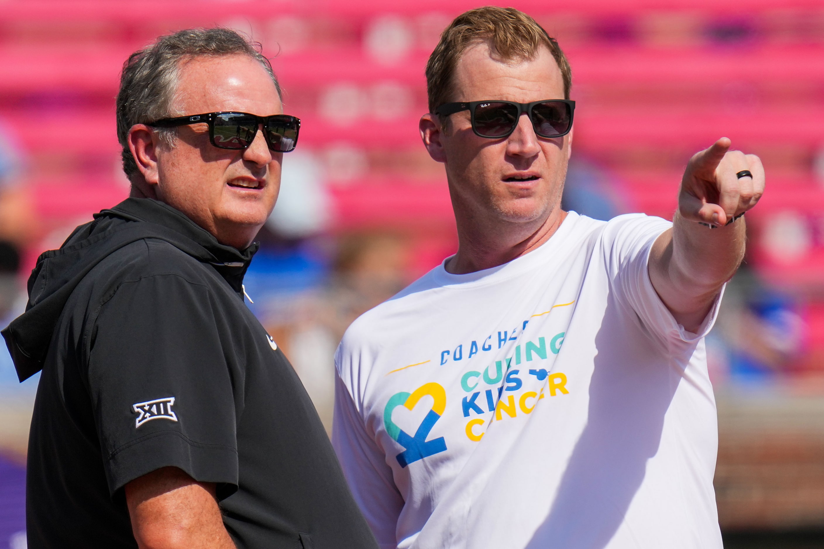 TCU head coach Sonny Dykes (left) and SMU head coach Rhett Lashlee talk at midfield before...