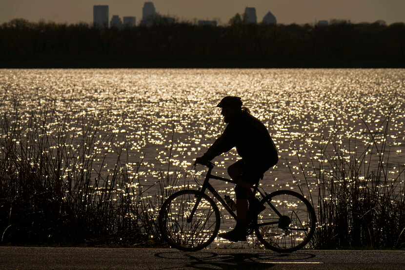 A cyclist takes advantage of a clear and sunny afternoon, with highs in the upper 60s, at...