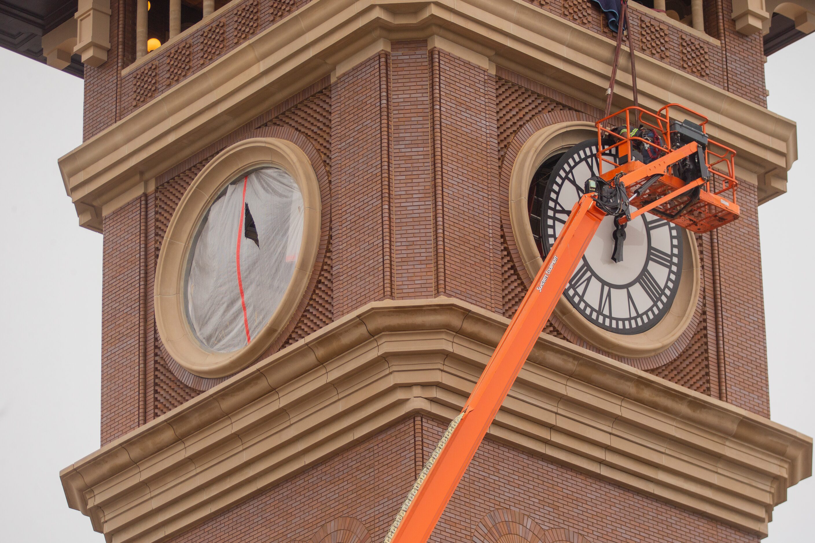 Workers from MEI Rigging & Crating work to install a 12-foot glass clock on the Grapevine...