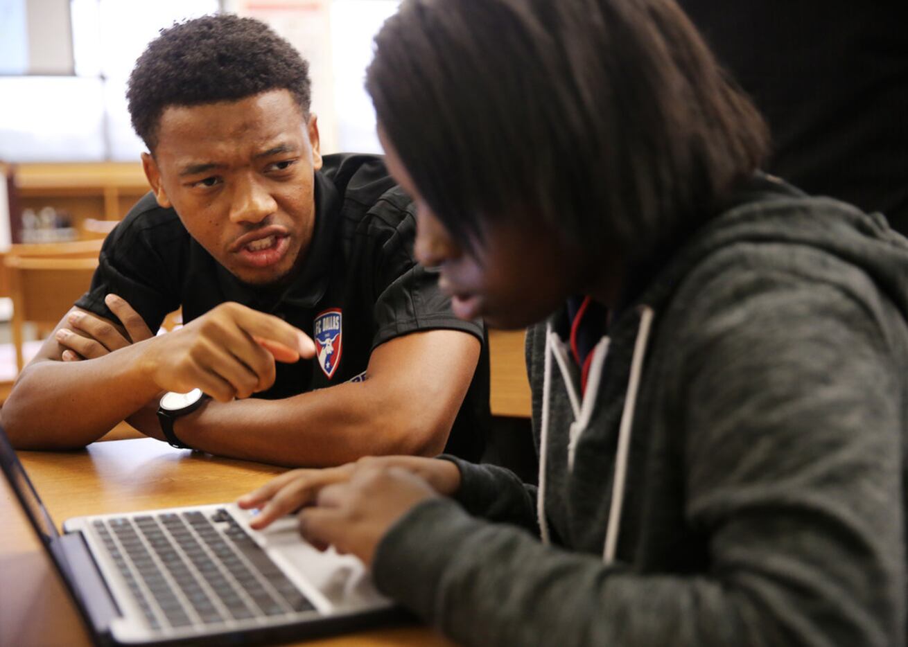 FC Dallas player Jacori Hayes works on a programming activity with a student during a...