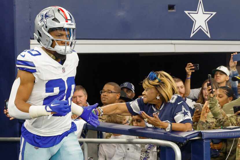 Dallas Cowboys running back Tony Pollard high-fives fans before the first half of an NFL...