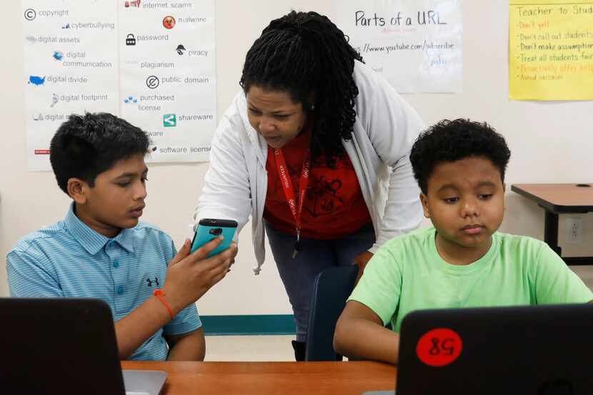 Deyonna Davis, teacher and sponsor of the coding club at Barbara Bush Middle School, helps...