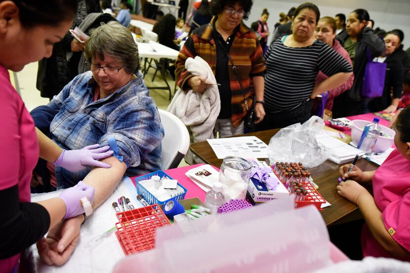 Sherry Boyd, left, had her blood collected for free lab tests during a health fair in Dallas...